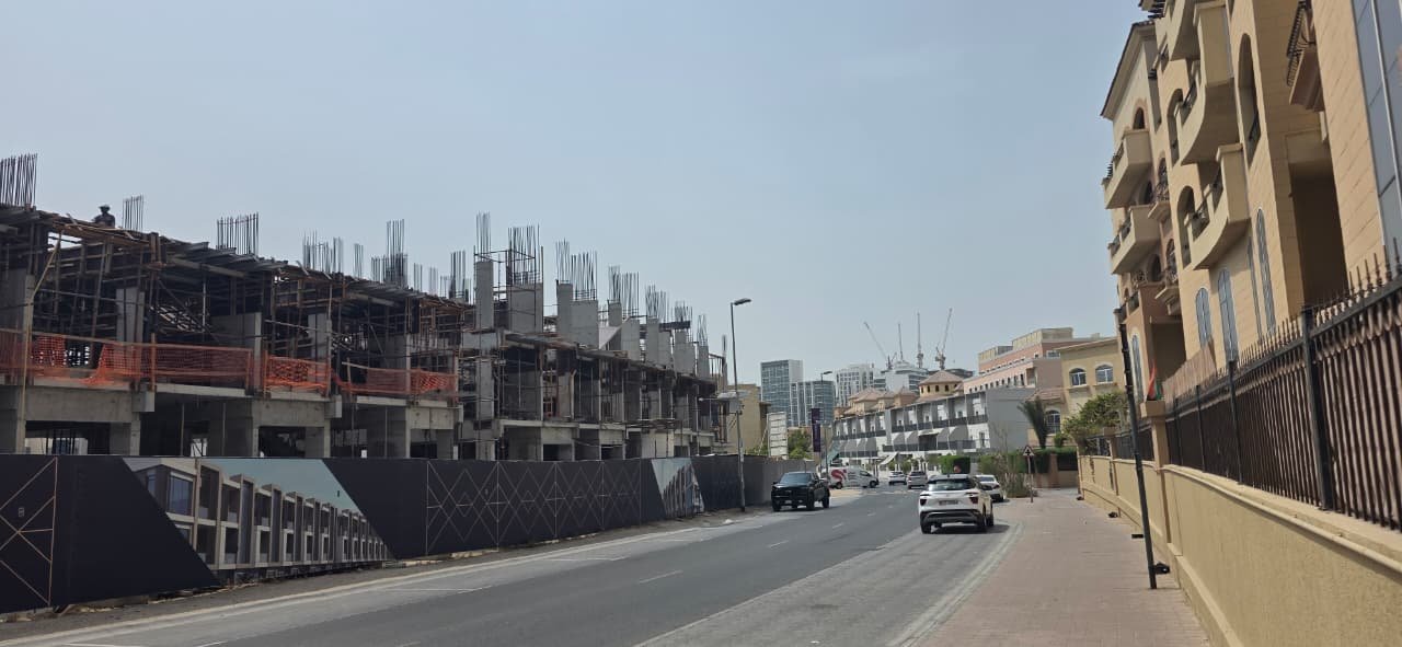 Construction hoarding with Dubai skyline in the background