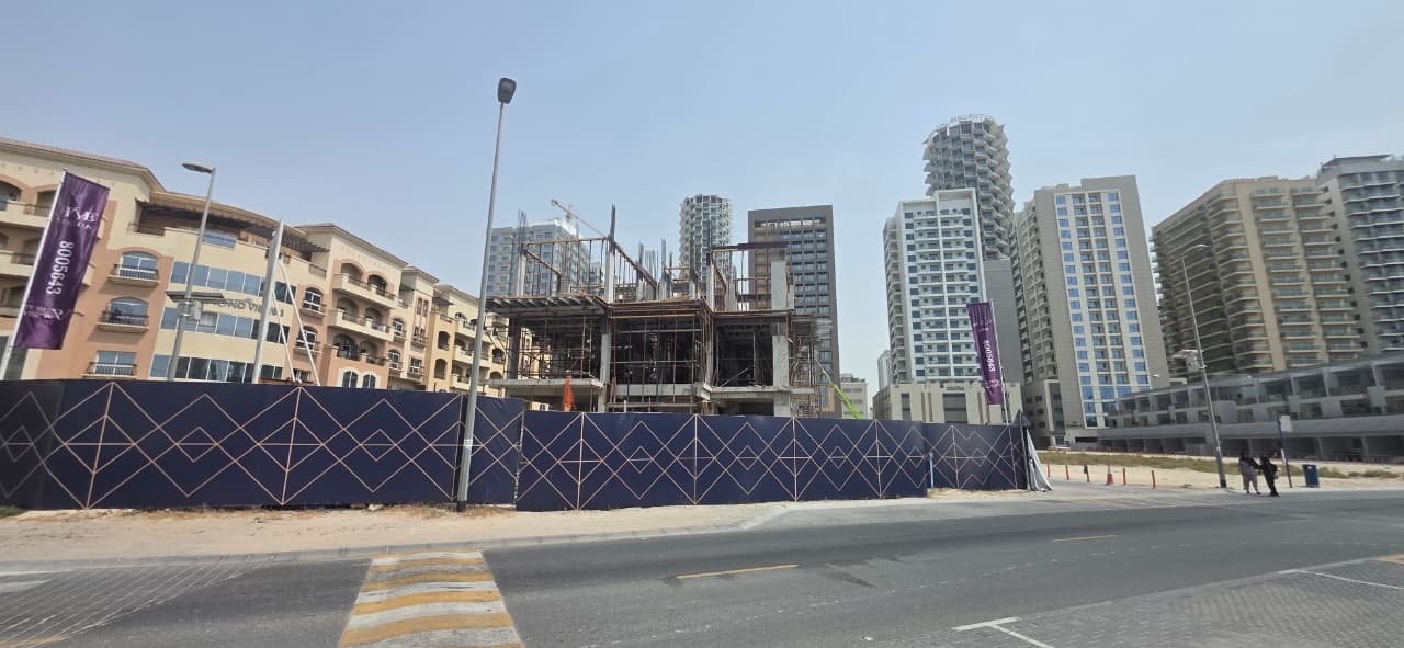 Street-level view of The Promise Villas construction site within its Jumeirah Village Circle streetscape